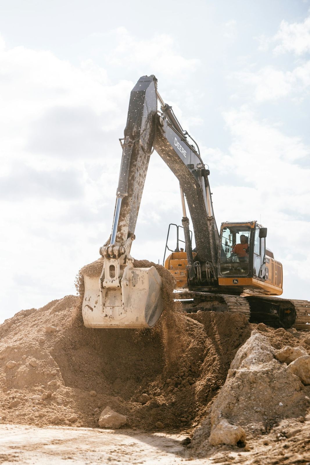 Excavator scooping a load of dirt at a construction site.