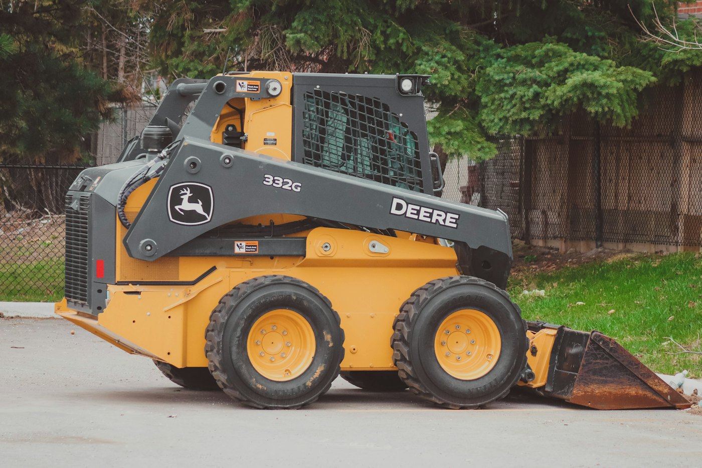 Yellow and black skid steer loader with a bucket, the kind of machine used for Bobcat services.
