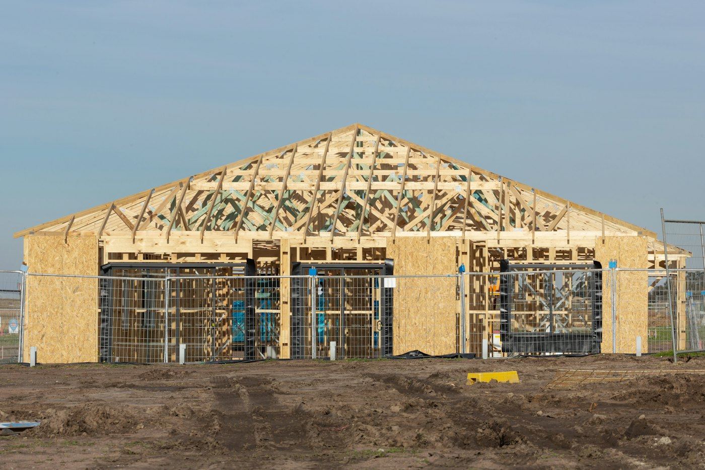Roof trusses and wall framing on a house still under construction.